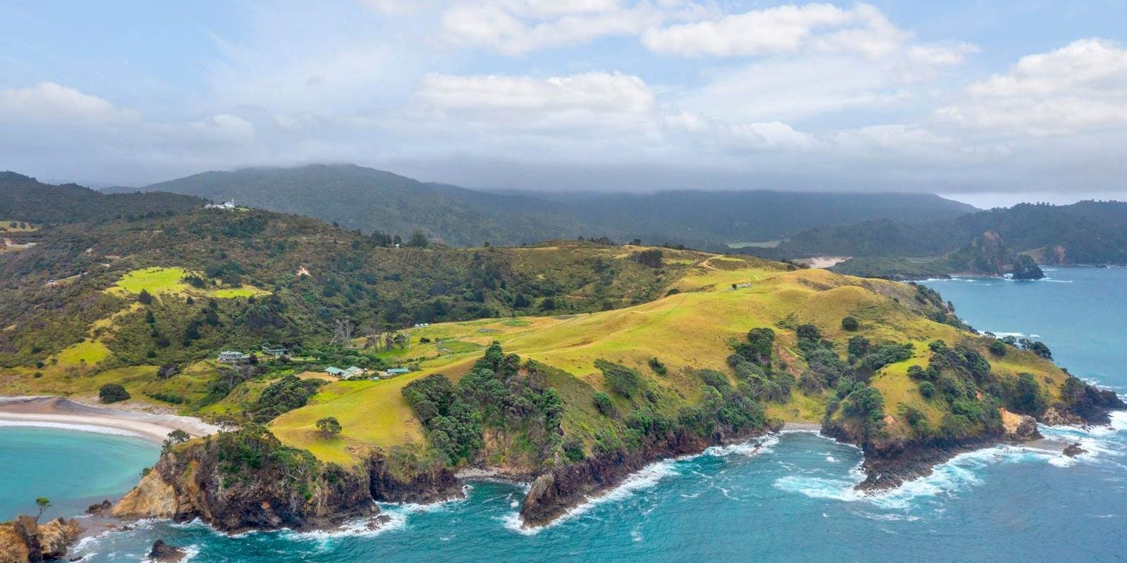 A breathtaking drone view of the Gray Family Farm, showcasing the sprawling peninsula property as it extends into the pristine waters of Great Barrier Island. Photo / Barfoot & Thompson