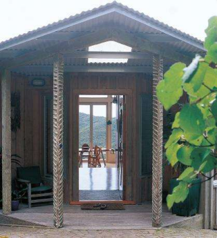 Nikau leaves have been braided around the posts at the front door. The scalloped roof line is visible from the garden. Each locally crafted dining chair is unique.