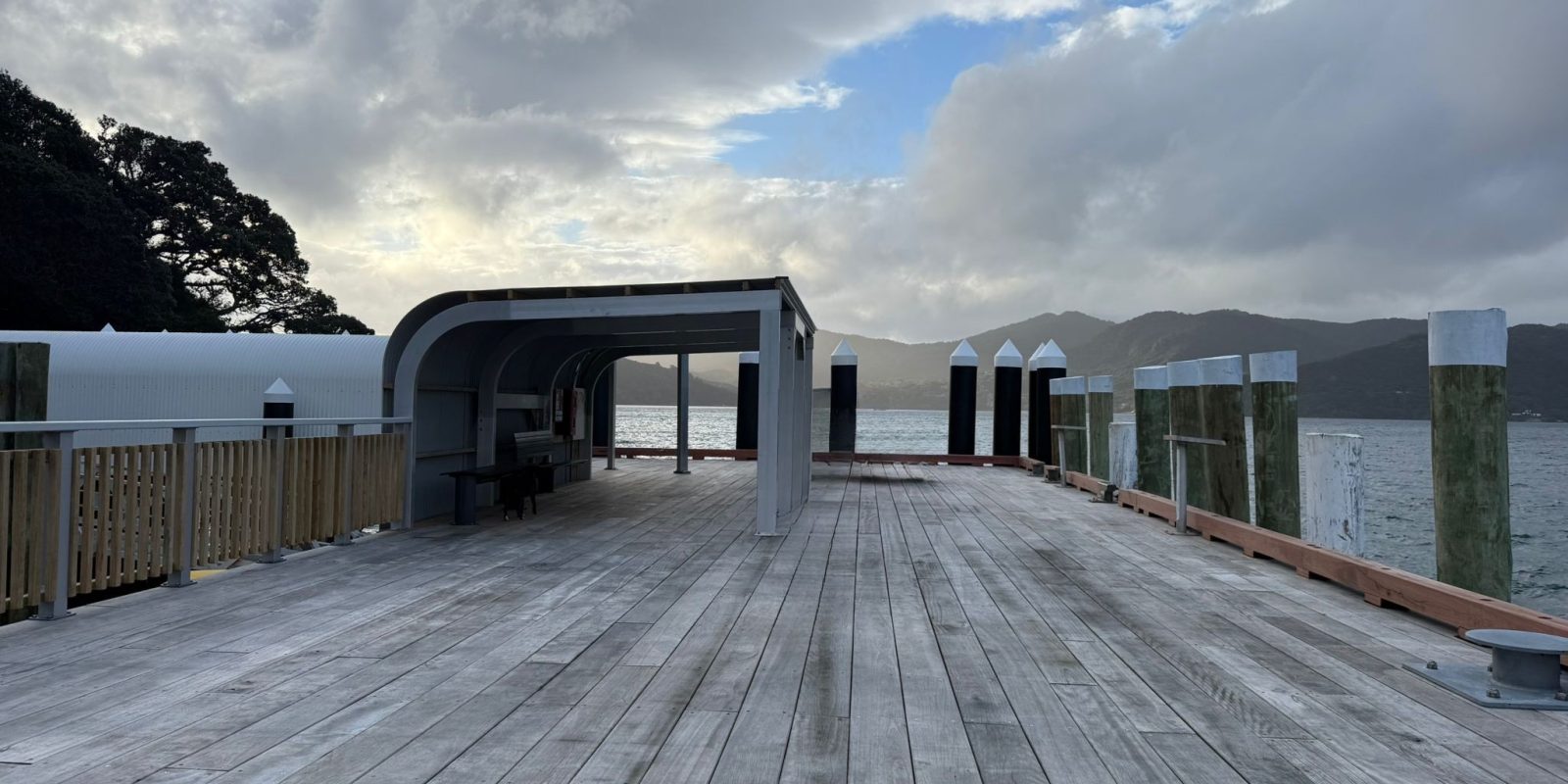 New hardwood benches sit beneath a steel-framed canopy at Tryphena Wharf, giving passengers shelter while they wait for ferries or collect freight.