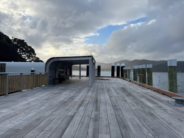 New hardwood benches sit beneath a steel-framed canopy at Tryphena Wharf, giving passengers shelter while they wait for ferries or collect freight.
