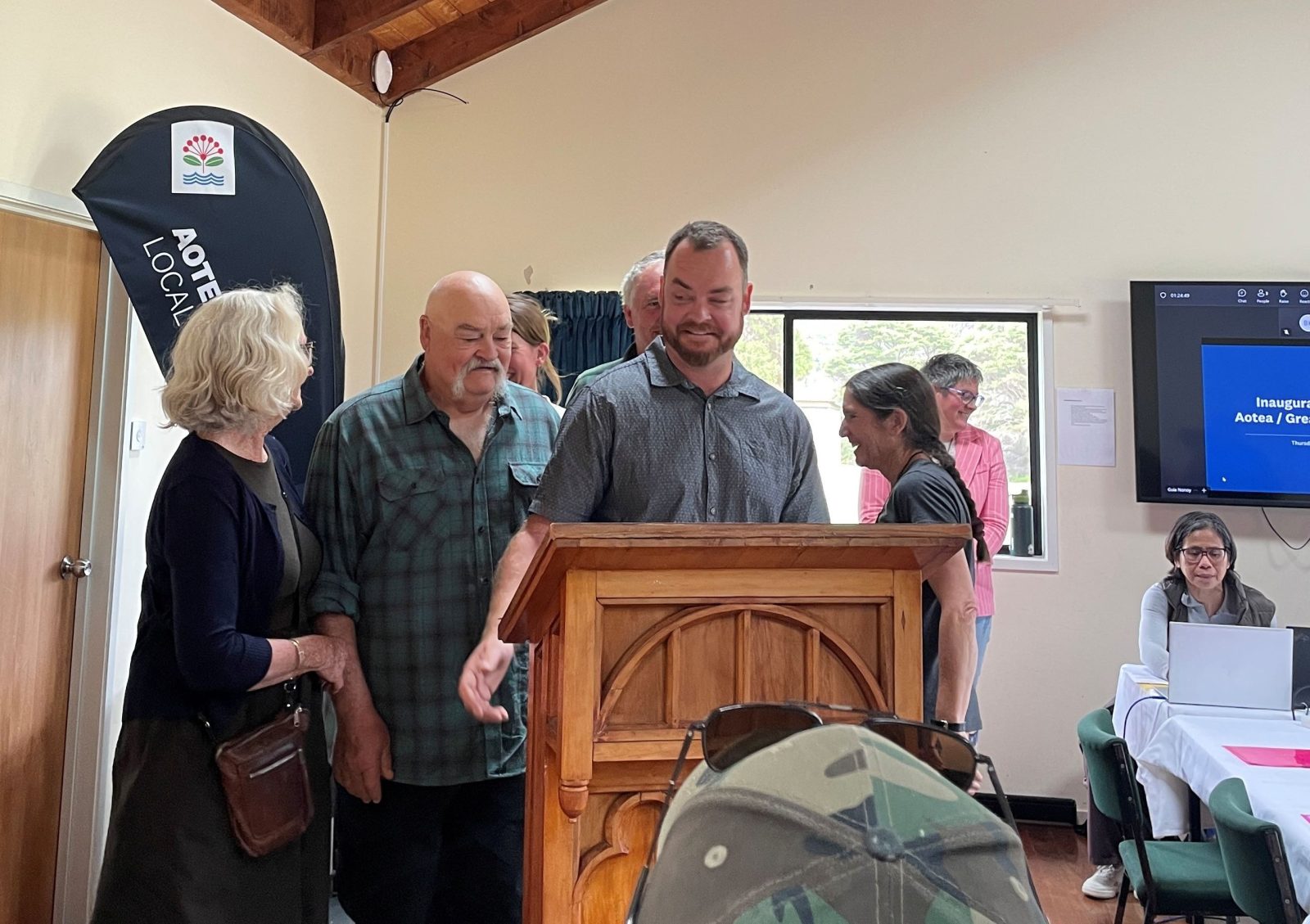 Ryan Daly reads his official declaration at the podium, joined by family including his mother Sue Daly — a former four-term Great Barrier Local Board member who retired in 2022.