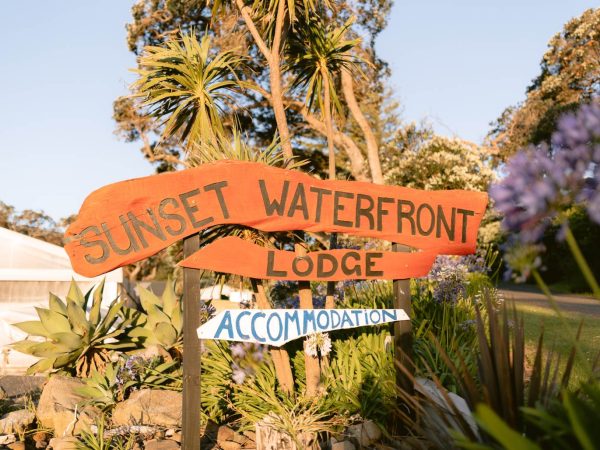 Sunset Waterfront Lodge sits opposite the beach at Mulberry Grove, a familiar landmark for visitors arriving in Tryphena.
