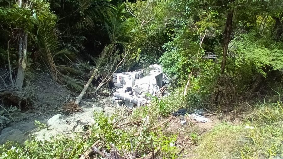 An Aotea Contractors truck lies at the bottom of a steep, bush-covered bank below Medland Road.