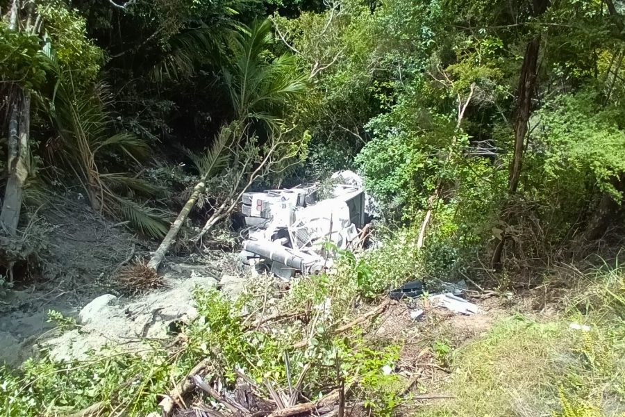 An Aotea Contractors truck lies at the bottom of a steep, bush-covered bank below Medland Road.